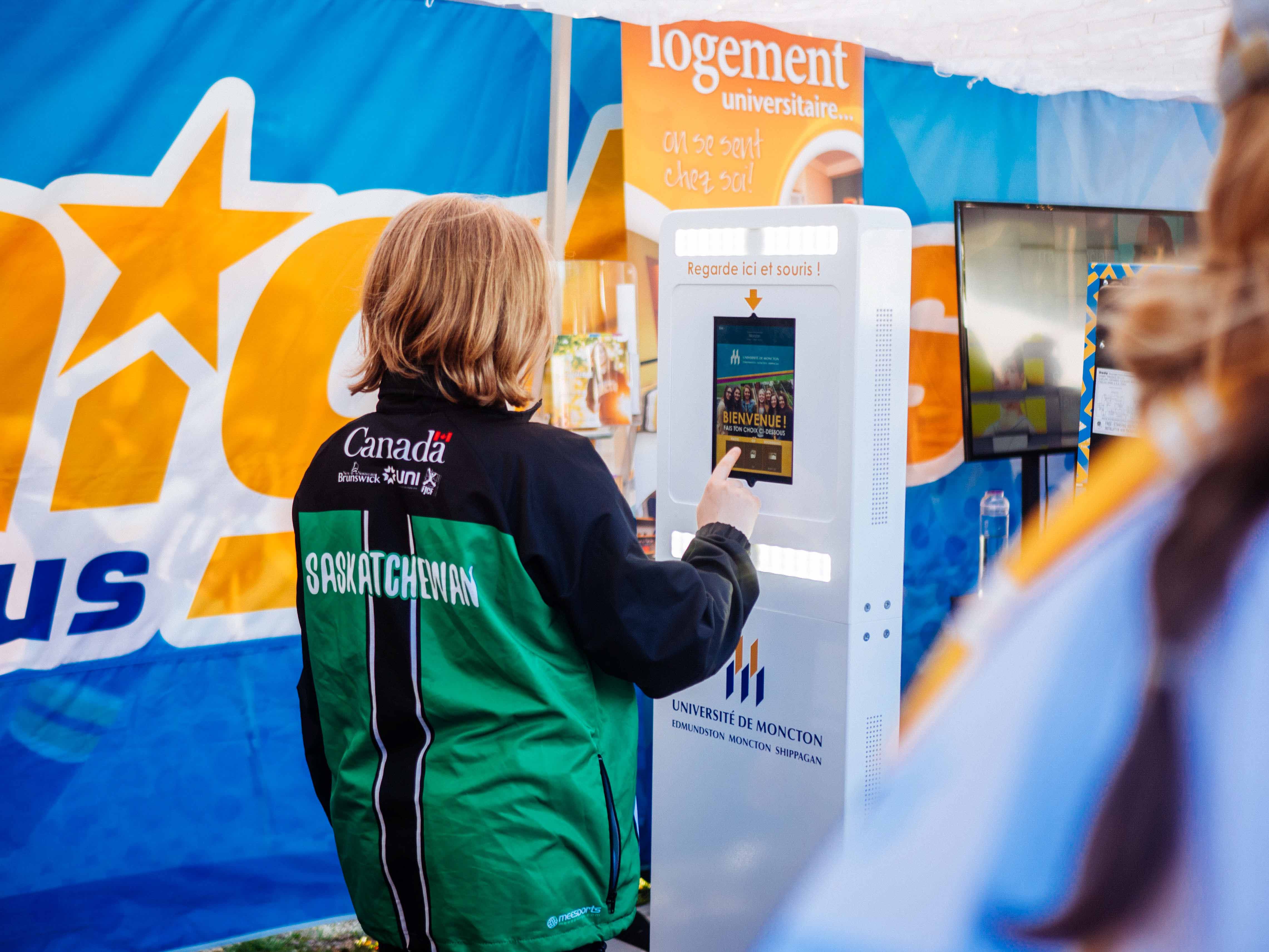 A guest interacting with a Memories2Go self-serve activation kiosk