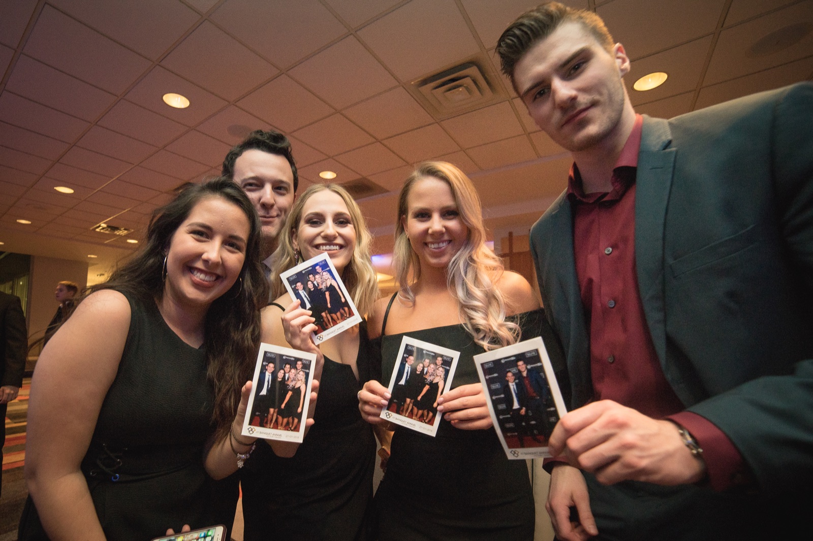 Guests at a corporate gala holding branded photo prints