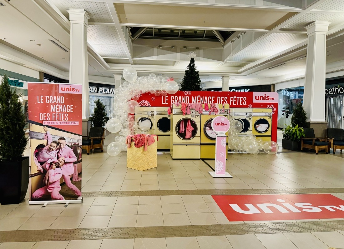 Le Grand Ménage des Fêtes activation — UNIS TV branded laundromat pop-up in a mall